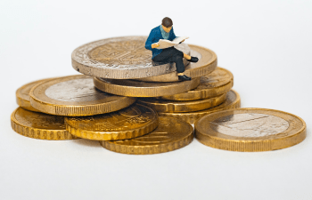 Person sitting on a pile of coins