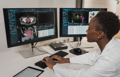 A doctor in front of two computer screens