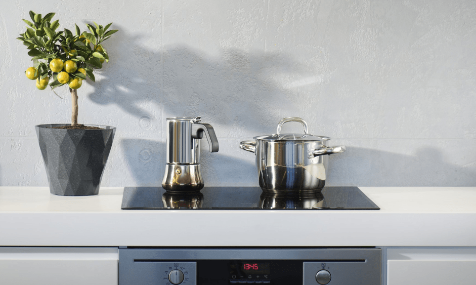 Kitchen hob with a coffee maker and a saucepan