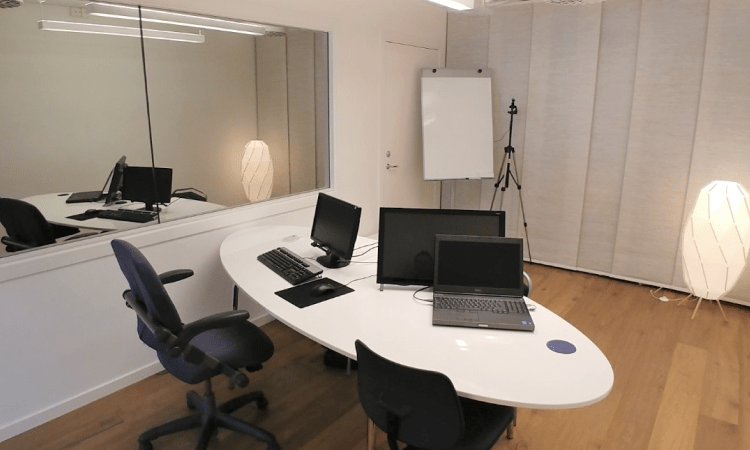 Desk with two computers and one screen