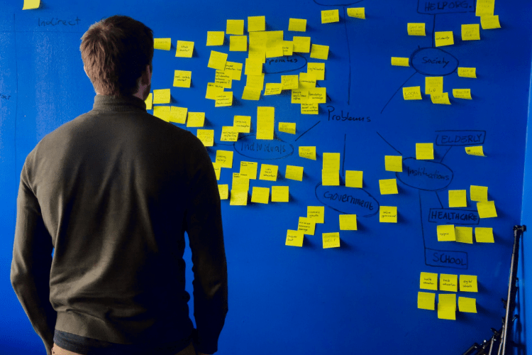 Person standing in front of a wall full of post-its